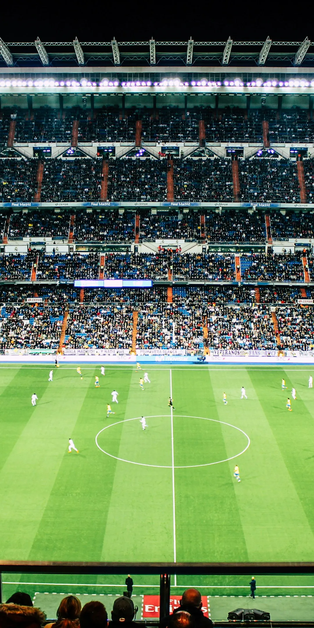 A packed stadium under floodlights during a night match